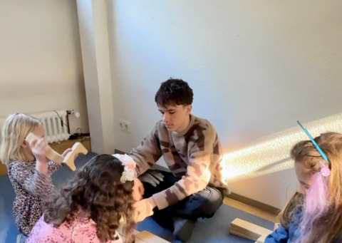 Praktikant mit drei Kindern am spielen
