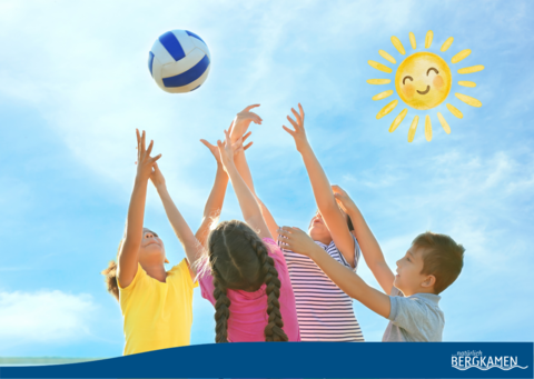 Vier Grundschulkinder spielen mit einem Ball