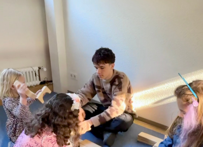 Praktikant mit drei Kindern am spielen