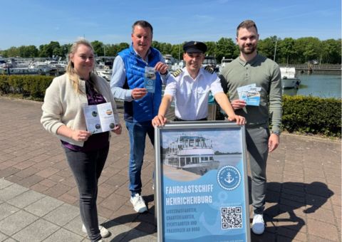 Captain Kraclke, Marvin Faulstich, Karsten Quabeck und Mareike Hindemitt vor dem neuen Anlegerschild der Henrichenburg 2