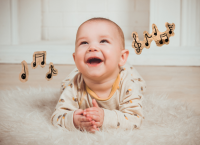 Ein kleines Baby hört auf der Decke Musik