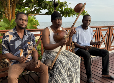 Tsira Ndong Bibang Trio auf einer Bank mit ihren Instumenten