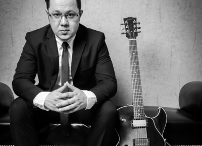 Mikhail Churilov auf der Couch mit seiner E-Gitarre