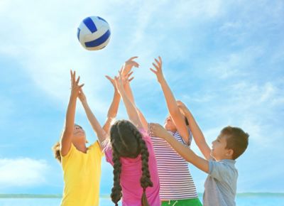 Vier Grundschulkinder spielen mit einem Ball