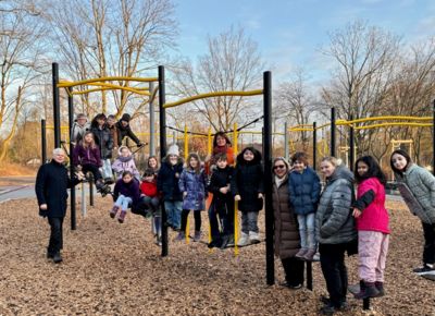 Bürgermeister Thomas Heinzel und Frau Busch zusammen mit den Kindern der Preinschule auf einem Klettergerüst