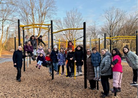 Bürgermeister Thomas Heinzel und Frau Busch zusammen mit den Kindern der Preinschule auf einem Klettergerüst