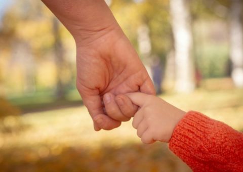 Vater hält mit Kind Händchen