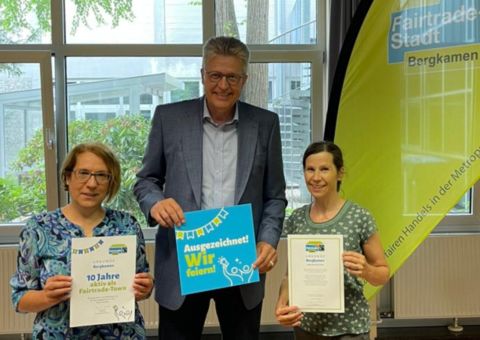 Foto mit Bürgermeister Schäfer mit der Urkunde 10 Jahre Fairtradestadt  Bergkamen