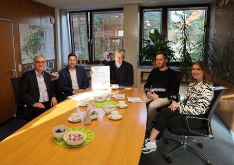 Bürgermeister und das Team "Sanieren mit Zukunft" sitzen an einem Tisch