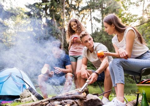 Jugendliche sitzen am Lagerfeuer
