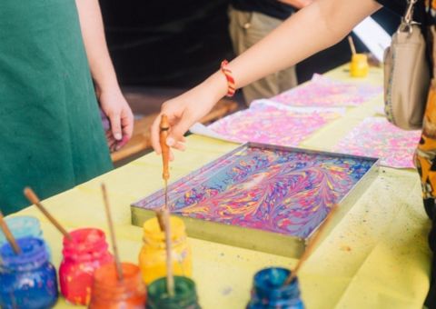 Basteltisch mit Kunstwerk das von Kindern gemalt wird