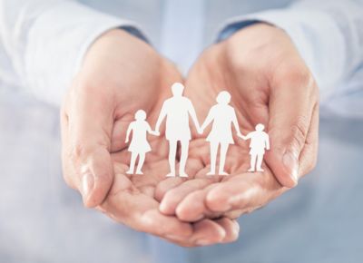 Abbildung einer Familie in einer offenen Hand